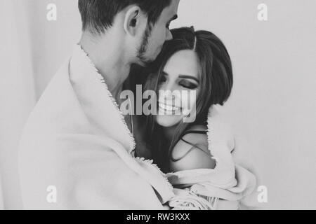 Portrait of young cheerful quel beau couple. Photo en noir et blanc. Happy woman laughing with closed eyes, maquillage sur le visage, la coiffure. Holding mâle Banque D'Images