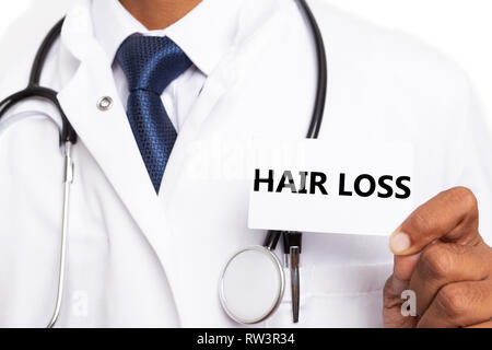 La perte de cheveux noir sur carte blanche présentée par Affaires indiennes médecin homme portant un sarrau close-up Banque D'Images
