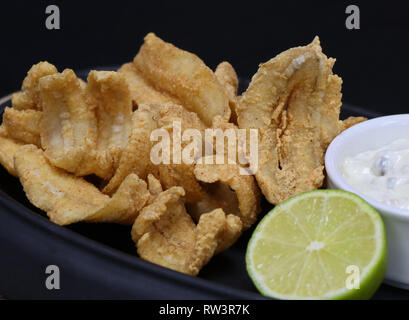 Anchois frits avec sauce tartare et de lime dans un plat de service Banque D'Images