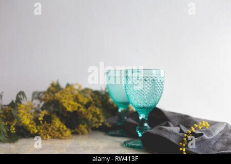 Vintage bleu jaune gobelets et mimosa . Sur l'arrière-plan. whight Wineglasses Banque D'Images
