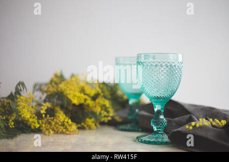 Vintage bleu jaune gobelets et mimosa . Sur l'arrière-plan. whight Wineglasses Banque D'Images