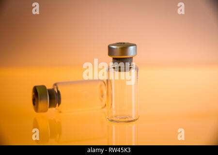 Deux bouteilles en verre sur fond orange Banque D'Images