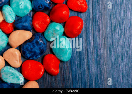 Des pierres de couleurs assorties sur fond bleu. Banque D'Images