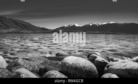 Stony Lake monochrome bord de lac Te Anau entouré de montagnes de Milford Banque D'Images