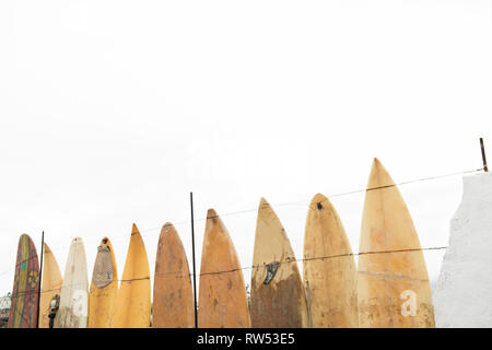 Notion de clôture faite de vieilles planches de surf grunge sale et ciel nuageux Banque D'Images
