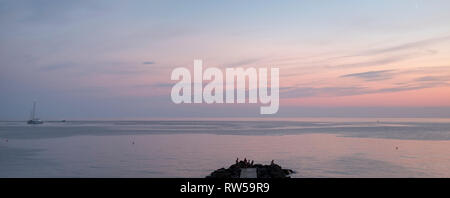 Vue panoramique sur la mer calme du soir avec un ciel rose Banque D'Images