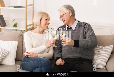 Happy senior couple drinking wine, célébrer un anniversaire de mariage Banque D'Images