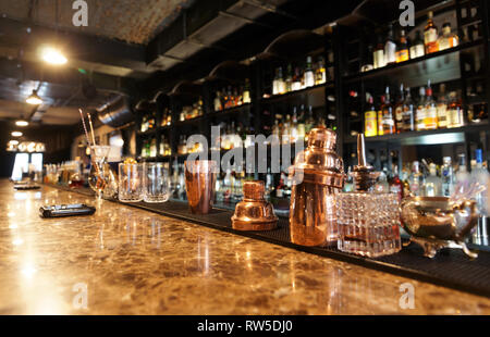 Comptoir de bar classique avec des bouteilles à l'arrière-plan flou Banque D'Images