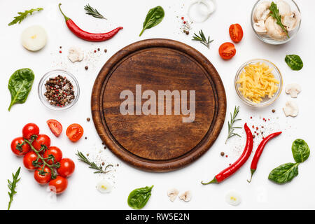 Planche à découper ronde avec ingridients pizza autour de Banque D'Images