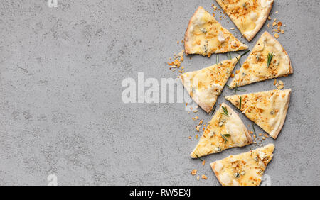 Pizza au fromage coupé en tranches sur fond gris Banque D'Images