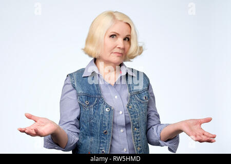 Portrait of a senior woman having nice un doute de geste. Qui sait ou je ne sais pas quoi choisir. Banque D'Images