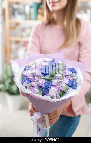 Bouquets de jacinthes bleues et matthiola de couleur lilas à main femme. Les fleurs de printemps à partir de la Dutch jardinier. Concept d'un fleuriste dans un magasin de fleur Banque D'Images