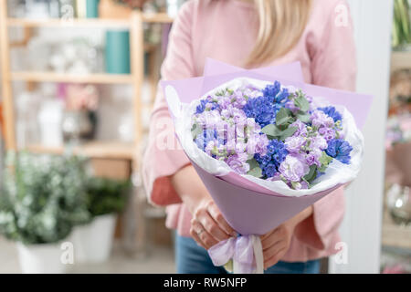 Bouquets de jacinthes bleues et matthiola de couleur lilas à main femme. Les fleurs de printemps à partir de la Dutch jardinier. Concept d'un fleuriste dans un magasin de fleur Banque D'Images