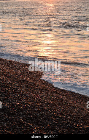 Le lever du soleil sur la plage à Budleigh Salteron sur la côte jurassique Site du patrimoine mondial à l'est du Devon, Angleterre du Sud-Ouest, Royaume-Uni. Banque D'Images