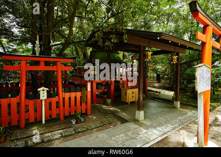 Deux portes torii vermillon se tenir près d'un petit lieu de culte dans la cour en face du Sanctuaire Shimogamo-jinja à Kyoto, au Japon, un jour d'été. Banque D'Images