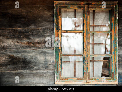 Abrégé d'une vieille maison de bois, vue rapprochée sur le châssis de fenêtre en bois et le mur. Banque D'Images