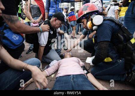 Caracas, Venezuela. 4e Mar, 2019. Une femme s'évanouit dans la chaleur intense pendant une manifestation en soutien de Juan Guaido alors que l'équipe de secours s'occuper d'elle. Juan Guaido, le chef de l'opposition vénézuélienne, où de nombreux pays ont reconnu que le président intérimaire légitime du Venezuela, salue ses partisans lors d'un rassemblement contre le gouvernement du président Nicolas Maduro à Caracas. Romain : crédit Camacho SOPA/Images/ZUMA/Alamy Fil Live News Banque D'Images