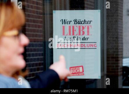 Leipzig, Allemagne. Le 05 Mar, 2019. Un employé de la Börsenverein des Deutschen Buchhandels est debout en face de la maison de livres sur une affiche avec l'inscription 'Celui qui aime books achète à la librairie'. La Börsenverein a présenté les programmes actuels des maisons d'édition central allemand pour la prochaine Foire du livre de Leipzig, qui aura lieu du 21.03. au 24.03.2019. Credit : Sebastian Willnow/dpa-Zentralbild/ZB/dpa/Alamy Live News Banque D'Images