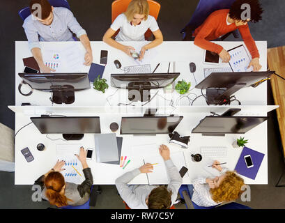 Diverses jeune équipe travaillant au lieu de coworking, vue du dessus Banque D'Images
