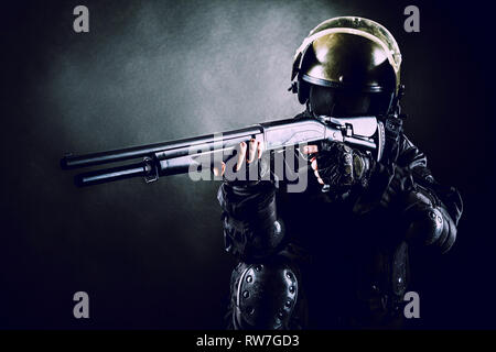 Soldat : Spec Ops sur fond noir avec le fusil de chasse. Banque D'Images