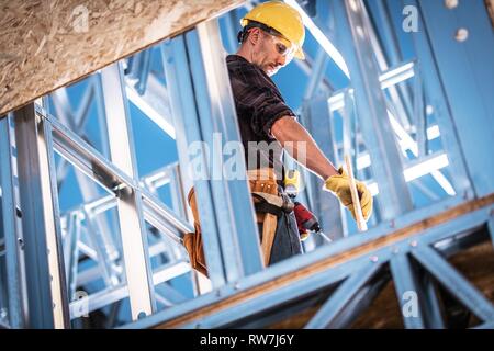 Caucasian Worker et le site de construction. Cadre en acier squelette de l'immeuble. Casque de zone. Banque D'Images