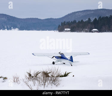 Un modèle expérimental de la Cub Carbone Piper Cub avion sur skis stationnée sur la neige et la glace sur le lac Pleasant, NEW YORK USA Banque D'Images