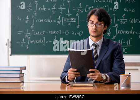 Jeune homme professeur de mathématique en classe Banque D'Images