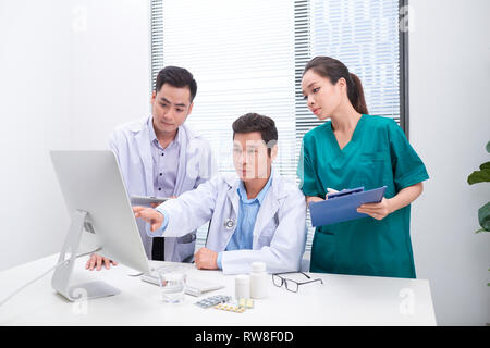 Trois médecins discuter sur des fichiers Office. Banque D'Images