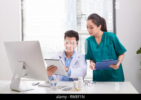 Groupe de médecins et d'infirmières l'examen rapport médical du patient. Équipe de médecins qui travaillent ensemble sur les patients à l'hôpital de fichier. Banque D'Images