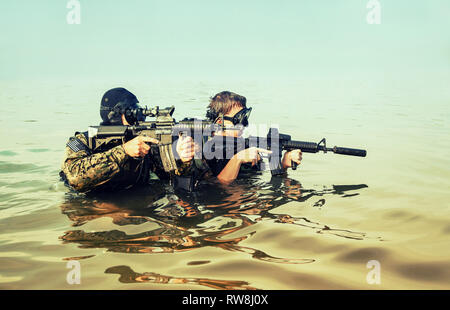 Plongeurs de Navy SEAL avec équipement de plongée complet et d'armes dans l'eau. Banque D'Images