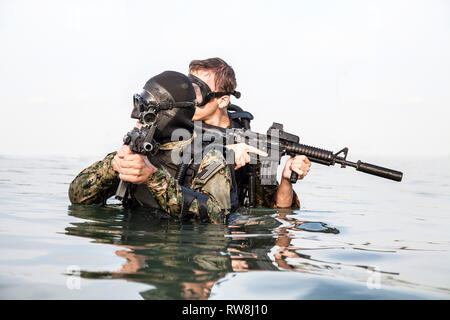 Plongeurs de Navy SEAL avec équipement de plongée complet et d'armes dans l'eau. Banque D'Images