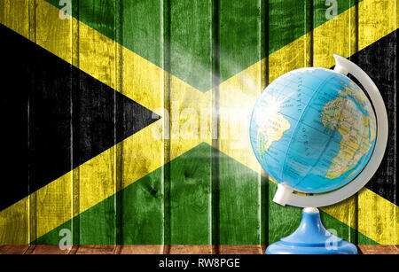 Globe avec une carte du monde sur un fond de bois avec l'image du drapeau de la Jamaïque. La notion de voyage et de loisir à l'étranger. Banque D'Images