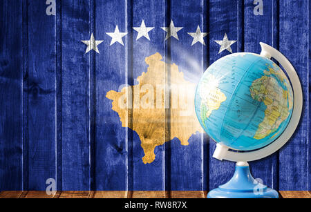 Globe avec une carte du monde sur un fond de bois avec l'image du drapeau du Kosovo. La notion de voyage et de loisir à l'étranger.