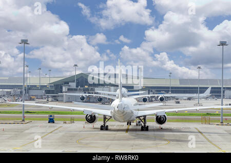 Vue sur l'aéroport avec l'avion au parking. Avion de derrière. Les avions dans l'aéroport. Nuages dans le ciel. Lieu vide pour le texte, copiez l'espace. Banque D'Images