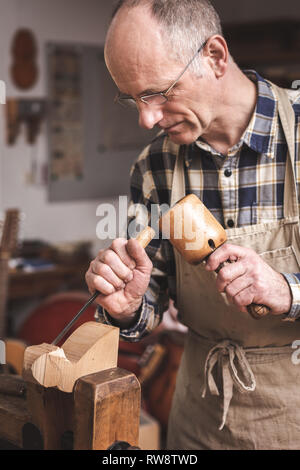 Sculpteur sur bois en collaboration avec le ciseau et mallet Banque D'Images