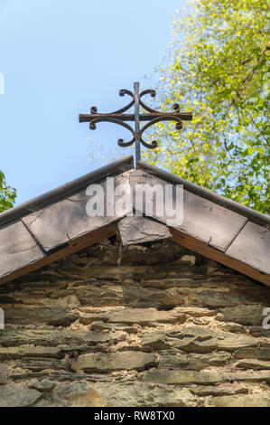 Gros plan sur la croix rouillée sur le toit d'une petite chapelle routière près de Maboge dans les Ardennes en Belgique. Banque D'Images