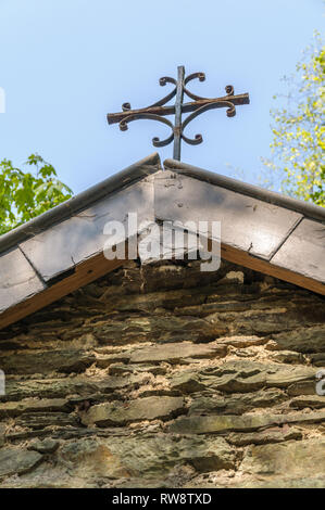 Gros plan sur la croix rouillée sur le toit d'une petite chapelle routière près de Maboge dans les Ardennes en Belgique. Banque D'Images
