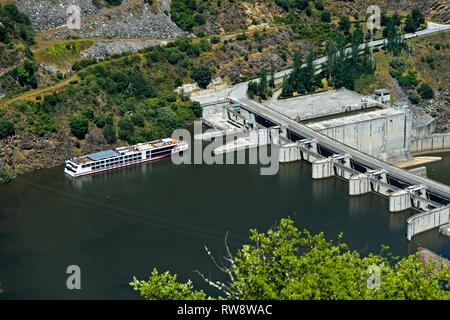 Excursion navire entrant dans la serrure de la centrale au fil de l'eau du barrage hydroélectrique de Valeira à la rivière Douro, Sao Joao da Pesqueira, Portugal Banque D'Images
