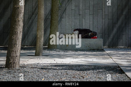 New York, USA - Décembre, 2018 : Afro-américains sans-abri dormir sur le banc de parc en plein air Banque D'Images