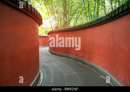 Passage de mur rouge en courbes, entouré de forêt de bambou appliqués colorés Chengdu Wuhou Temple de la Chine. Banque D'Images