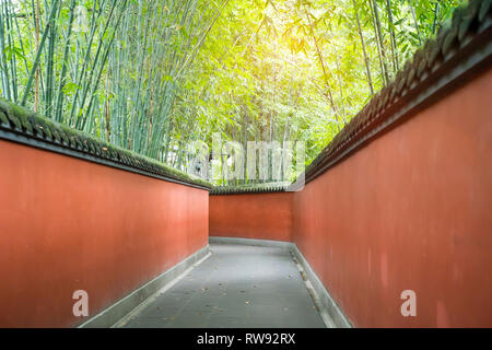 Passage de mur rouge en courbes, entouré de forêt de bambou appliqués colorés Chengdu Wuhou Temple de la Chine. Banque D'Images