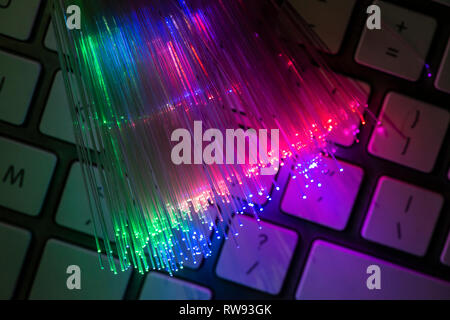 Fibres optiques colorés illuminé sur clavier. Internet haute vitesse gratuit. Transfert de données câble optique. Bande de beaucoup de fibres optiques, glowing di Banque D'Images