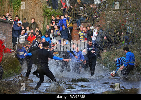 Les joueurs prennent part au match de football des Jours gras Royal à Ashbourne, dans le Derbyshire, qui a été joué depuis le 12ème siècle. Banque D'Images