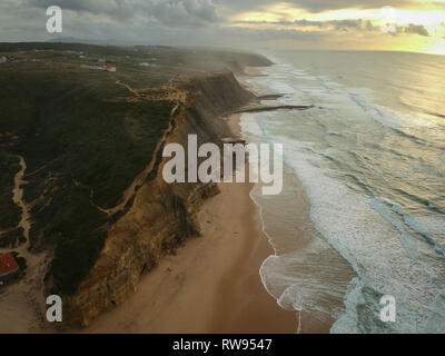 Vue aérienne d'une plage de sable au coucher du soleil avec une étonnante falaise. Portugal Banque D'Images