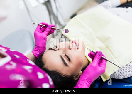 Jeune femme ayant le dentiste jusqu'au bureau du dentiste, smiling, looking at camera. Banque D'Images