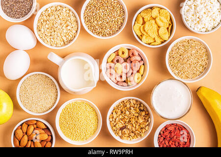 Ingrédients pour un petit-déjeuner sain - céréales, grains, produits laitiers, graines, noix et fruits. Banque D'Images