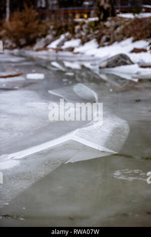 L'épaisseur de la glace sur le lac gelé à Vorderer Langbathsee. De belles montagnes aux sommets enneigés reflètent dans le crystal clear lake Banque D'Images