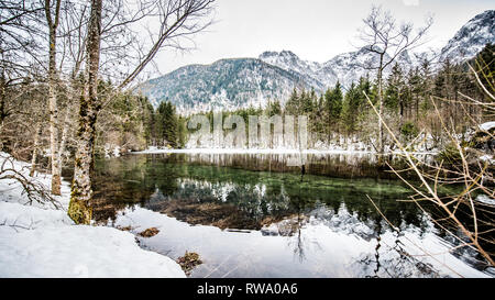 L'épaisseur de la glace sur le lac gelé à Vorderer Langbathsee. De belles montagnes aux sommets enneigés reflètent dans le crystal clear lake Banque D'Images