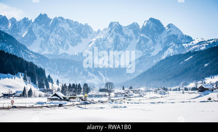 Beau blanc hiver neige scène du village autrichien de Gosau avec montagnes aux sommets enneigés au loin Banque D'Images