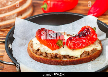 Le pain grillé avec de la viande hachée, le fromage et le poivre rouge. Délicieux sandwich ouvert. Selective focus Banque D'Images